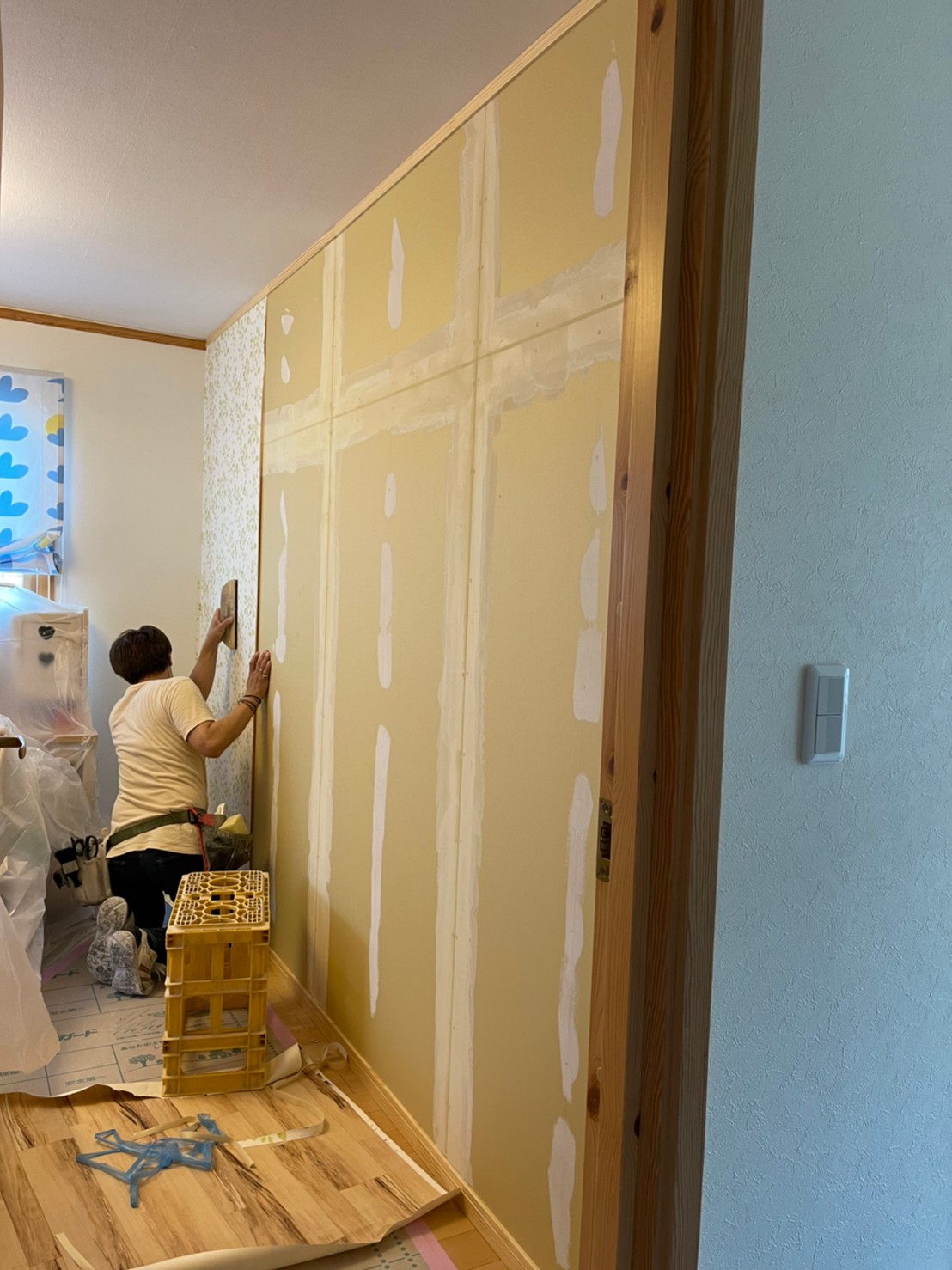 施工途中【子ども部屋】新しい間仕切り壁へ、内装屋さんが壁紙を施工中